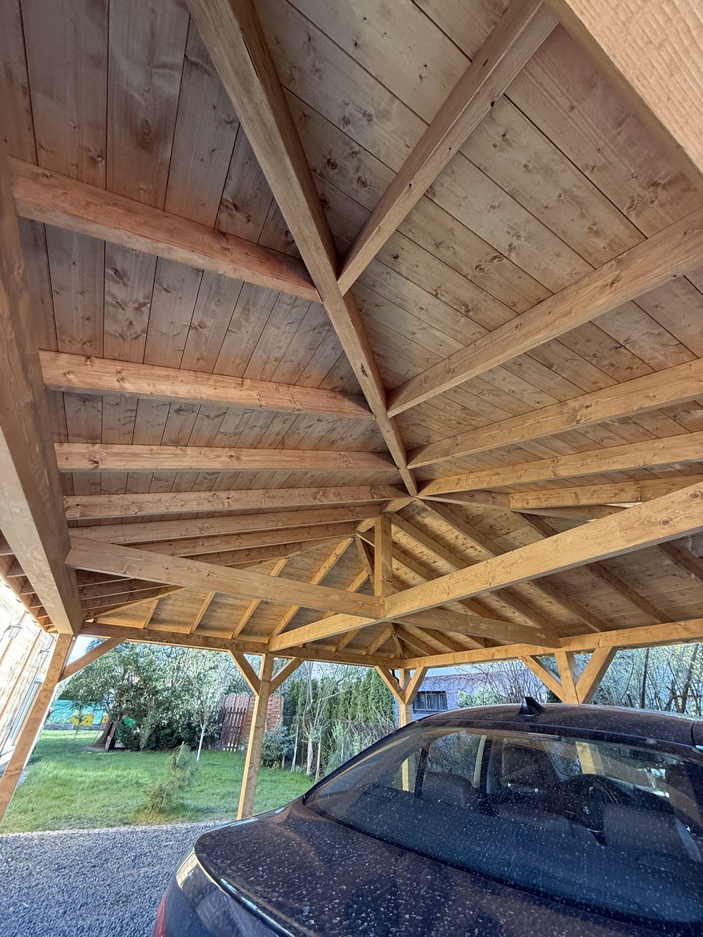 Budowa carportu z drewna dopasowanego do elewacji domu i podjazdu